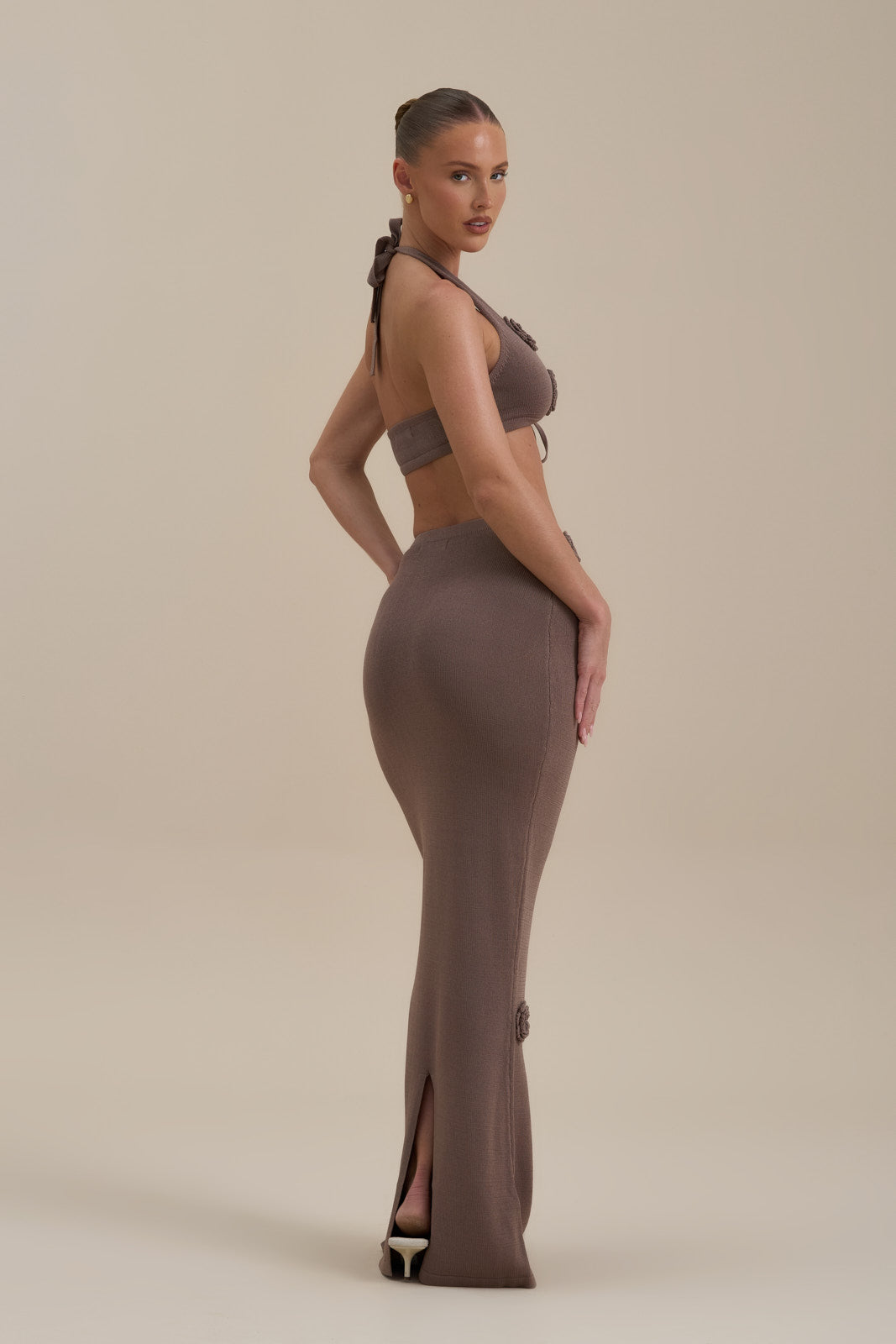 Model wearing Daisy Maxi Skirt in Mocha Mousse, sitting, showing 3D floral appliqués - Wanderdoll